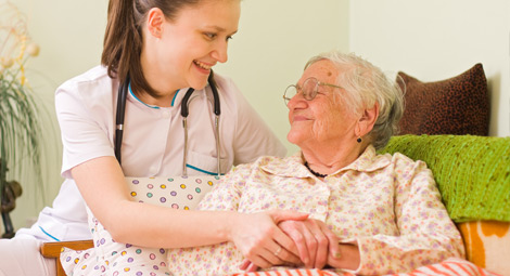 An older woman being visited by a healthcare professional at home